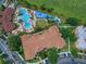 Overhead view of a community building, parking and pool area featuring waterslides and lake views at 7719 Comrow St, Kissimmee, FL 34747