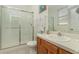Functional bathroom featuring a glass door shower, wooden vanity, and tile flooring at 7719 Comrow St, Kissimmee, FL 34747