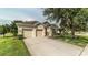 Charming single-story home featuring a two-car garage, well-manicured lawn, and mature landscaping at 7719 Comrow St, Kissimmee, FL 34747