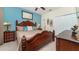 Comfortable main bedroom featuring a large bed with detailed headboard and dresser with closet access at 7719 Comrow St, Kissimmee, FL 34747