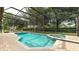 Screened-in pool with a spa and brick paved deck, surrounded by well-maintained landscaping at 7719 Comrow St, Kissimmee, FL 34747