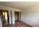 Bedroom with outdated pink carpet and view to kitchen area and open closet at 8 Emerald Way, Ocala, FL 34472