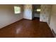 Bedroom featuring wood flooring, simple window, dated wallpaper and view into bathroom at 8 Emerald Way, Ocala, FL 34472