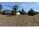 Ranch-style house surrounded by trees, sky, and a well-maintained yard at 8 Emerald Way, Ocala, FL 34472