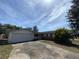 Single-story home with an attached two-car garage and a driveway in front, under a bright sky at 8 Emerald Way, Ocala, FL 34472