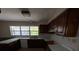 Outdated kitchen featuring wooden cabinets, laminate countertop, a window, and standard appliances at 8 Emerald Way, Ocala, FL 34472