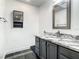 Renovated bathroom features a gray vanity with a marble countertop and a decorative framed mirror at 832 Whalebone Bay Dr, Kissimmee, FL 34741