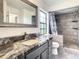 Updated bathroom features a sink with a marble countertop, framed mirror, and decorative tiled shower at 832 Whalebone Bay Dr, Kissimmee, FL 34741