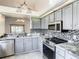 Open-concept kitchen with stainless steel appliances, eat-in bar, and gray cabinets at 832 Whalebone Bay Dr, Kissimmee, FL 34741