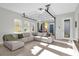 Cozy living room with sectional sofa, large windows, and glass garage door for indoor-outdoor living at 8338 Modiano St, Orlando, FL 32827