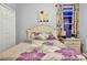 Cozy bedroom showcases a white bed frame, wood-look flooring, and neutral décor at 932 Emerald Green Ct, Kissimmee, FL 34746