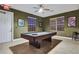 Billiard room with a pool table, ceiling fan, and natural light, offering a recreational space at 932 Emerald Green Ct, Kissimmee, FL 34746