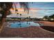 Relaxing community pool and lounge area surrounded by palm trees at sunset at 932 Emerald Green Ct, Kissimmee, FL 34746