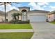 Charming single-story home with a two-car garage, well-manicured lawn, and decorative landscaping at 932 Emerald Green Ct, Kissimmee, FL 34746