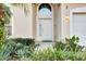 Inviting front entrance with decorative plants and sidelight windows allowing natural light into the home at 932 Emerald Green Ct, Kissimmee, FL 34746