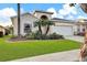 Beautiful home featuring a lush green lawn and mature palm trees in a well-maintained front yard at 932 Emerald Green Ct, Kissimmee, FL 34746