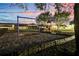 Well maintained playground area with mature trees on a common green space at twilight at 932 Emerald Green Ct, Kissimmee, FL 34746