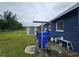 Fully-fenced backyard features a storage shed, lawn, clothesline, and blue painted home exterior at 1617 Emmett St, Kissimmee, FL 34741