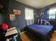 Cozy bedroom featuring a bed, dark blue walls, curtains, and decor at 1617 Emmett St, Kissimmee, FL 34741