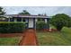 Cozy single-story home has front yard landscaping with trimmed shrubs and flower garden at 1617 Emmett St, Kissimmee, FL 34741
