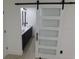Modern bathroom entrance featuring a barn door and a view of dual vanities at 527 Stillwater Dr, Oviedo, FL 32765