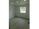 Clean, minimalist bedroom with wood-look floors and ample natural light from the window at 527 Stillwater Dr, Oviedo, FL 32765