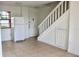 Bright entryway with neutral tile floors, a white refrigerator, and staircase leading to the upper level at 10330 Turkey Lake Rd # A-4 Ak/A 107, Orlando, FL 32819