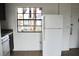 Functional kitchen with a white refrigerator, stylish cabinetry, and a sunlit window at 10330 Turkey Lake Rd # A-4 Ak/A 107, Orlando, FL 32819