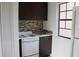 Efficient kitchen includes modern cabinets, mosaic backsplash, and white appliances for a clean look at 10330 Turkey Lake Rd # A-4 Ak/A 107, Orlando, FL 32819