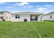 Spacious backyard with lush green grass and a view of the home's exterior at 1126 Olivine Ave, Dundee, FL 33838