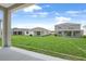 View of the backyard featuring a lush lawn and neighboring homes at 1126 Olivine Ave, Dundee, FL 33838