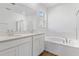 Elegant bathroom with double sinks, a soaking tub, and a separate glass-enclosed shower at 1126 Olivine Ave, Dundee, FL 33838