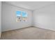 Bright bedroom with a neutral carpet, white walls, and a window letting in natural light at 1126 Olivine Ave, Dundee, FL 33838