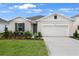 Charming single-story home boasts a manicured lawn and an attached two-car garage at 1126 Olivine Ave, Dundee, FL 33838