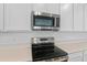 Close-up of stainless steel kitchen appliances, including a microwave and range at 1126 Olivine Ave, Dundee, FL 33838
