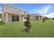 Well-manicured backyard with lush lawn, mature trees, and covered patio perfect for outdoor living at 1650 Sugarbelle Cir, Mascotte, FL 34753