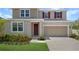 Charming two-story home featuring red shutters, neutral siding, manicured lawn, and a two-car garage at 1650 Sugarbelle Cir, Mascotte, FL 34753