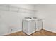 Bright laundry room with white washer and dryer, shelving, and tile flooring at 1650 Sugarbelle Cir, Mascotte, FL 34753