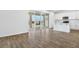 Open-concept space with sliding glass doors leading to backyard, view of the kitchen, and wood-look floors at 1650 Sugarbelle Cir, Mascotte, FL 34753
