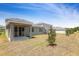 Backyard features an open lawn and covered porch at 1690 Sugarbelle Cir, Mascotte, FL 34753
