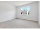 Spacious bedroom with neutral carpet, white walls, and a large window with outdoor views at 1690 Sugarbelle Cir, Mascotte, FL 34753
