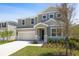 Two-story home with attached garage, neutral siding, stone accents, manicured lawn, and appealing curb appeal at 1690 Sugarbelle Cir, Mascotte, FL 34753