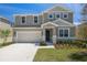 Charming two-story home featuring a two-car garage, stone accents, neutral colors, and well-maintained landscaping at 1690 Sugarbelle Cir, Mascotte, FL 34753