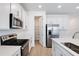 Bright kitchen featuring stainless steel appliances, white cabinets, an island, and a convenient pantry at 1690 Sugarbelle Cir, Mascotte, FL 34753