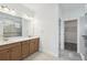 Bathroom featuring double sinks, neutral tile, shower, and access to the walk-in closet at 204 Bella Cortina Dr, Poinciana, FL 34759