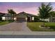 Charming single-story home features a brick driveway, two-car garage, and well-manicured lawn at 204 Bella Cortina Dr, Poinciana, FL 34759