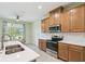 Cozy kitchen with stainless steel appliances, light wood cabinetry, and white countertops at 204 Bella Cortina Dr, Poinciana, FL 34759
