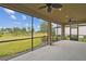 Spacious screened lanai with ceiling fans offering a view of the lush backyard and expansive green space at 204 Bella Cortina Dr, Poinciana, FL 34759