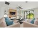 Bright living room features built-in shelves, a wood accent wall, and sliding glass doors to the backyard at 204 Bella Cortina Dr, Poinciana, FL 34759
