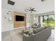Bright living room features built-in shelving, wood accent wall, and sliding glass doors to the outdoor space at 204 Bella Cortina Dr, Poinciana, FL 34759